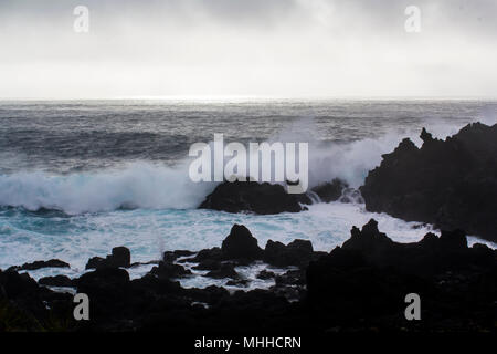 Vagues se briser contre les formations de roche volcanique noire Banque D'Images