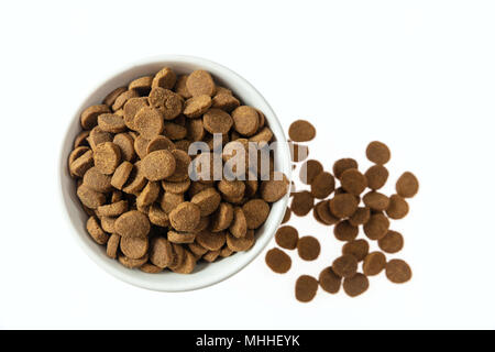 Animaux domestiques aliments secs. Croquette chiens nourriture dans un bol blanc isolé sur fond blanc, vue du dessus Banque D'Images