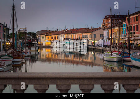 Vue sur Porto Canale, le canal central dans la belle ville de Cesenatico, sur la côte Adriatique en Italie. pont Bannister au premier plan. Banque D'Images