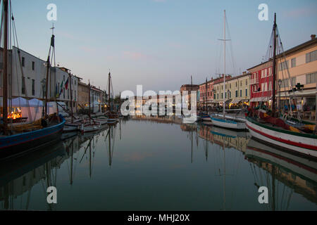 Vue sur Porto Canale, le canal central dans la belle ville de Cesenatico, sur la côte Adriatique en Italie. La tombée de la lumière. Banque D'Images