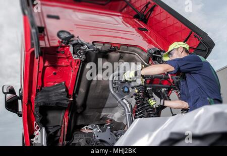 Camion semi sous Maintenance. Caucasian mécanicien travaillant pour réparer le tracteur. Banque D'Images