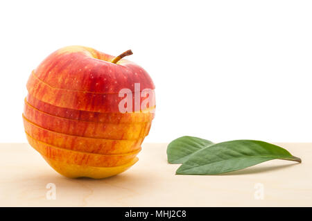 Apple a conservé sa forme, mais coupé en tranches sur une table en bois. Banque D'Images