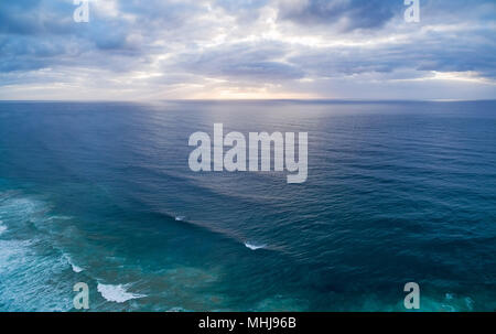 Antenne minimaliste panorama de coucher de soleil sur l'eau sous moody sky Banque D'Images