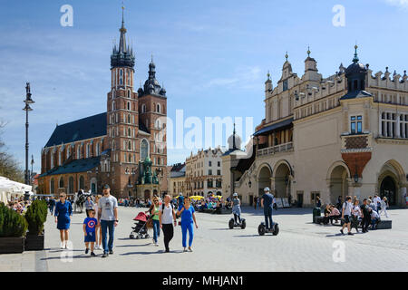 Cracovie, Pologne - le 14 avril 2018 : les touristes visitent la place principale, qui célèbre l'architecture historique d'une journée ensoleillée. Banque D'Images