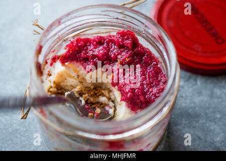 Cheesecake fruits des bois dans un pot avec une cuillère. Dessert / Inachevé. L'alimentation biologique. Banque D'Images