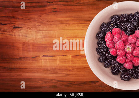 Plaque avec des petits fruits sur la table en bois Banque D'Images