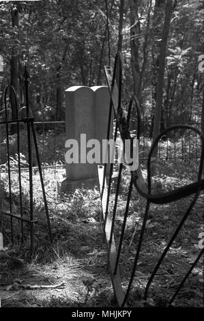 Pierres tombales brisées et d'escrime tordues sont trouvés dans un négligé confederate cemetery près de Fayetteville, Arkansas. Banque D'Images