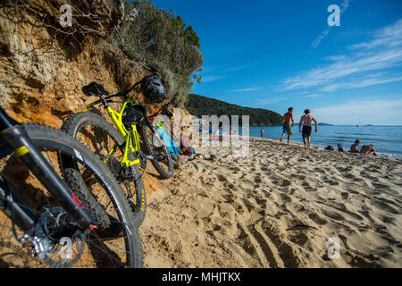 Deux hommes courir dans la mer après un vtt à Punta Ala, Toscane, Italie. Banque D'Images