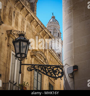 Lecce (Italie), août 2017. Vue de la partie supérieure de la tour de la cloche de la cathédrale baroque de Lecce de la rue adjacente appelée Corte dei Cicala. Banque D'Images