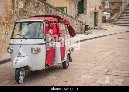 Matera (Italie), septembre 2017. Les touristes sur un Piaggio Ape Calessino utilisé comme un taxi. Le format paysage. Banque D'Images