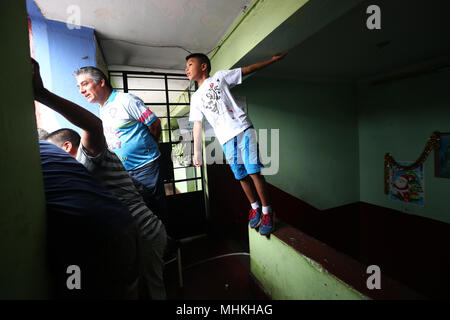 01 mai 2018, Lima, Pérou : un jeune garçon et un autre membre de l'auditoire regarder le match de foot de rue "undialito'. Pour la 60e fois, les passe-temps joueurs de football ont réalisé cette rue match dans la capitale de Lima au Pérou. Plusieurs fans encourageaient leurs équipes dans une rue peu recommandables dans le district de La Victoria. Les supporters de football payés jusqu'à 1 000 soles (255 euros) pour des sièges de loge aux fenêtres des maisons limitrophes. Photo : Geraldo Caso Bizama/dpa Banque D'Images