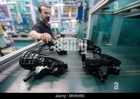17 avril 2018, l'Allemagne, Ludwigsburg : un membre du personnel de l'équipementier automobile et spécialiste des filtres Mann Hummel, prend le boîtier pour une huile d'un modul assmebly banc dans le hall d'assemblage de l'entreprise. Photo : Marijan Murat/dpa Banque D'Images