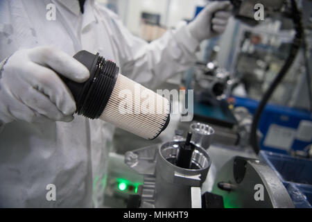 17 avril 2018, l'Allemagne, Ludwigsburg : un membre du personnel de l'équipementier automobile et spécialiste des filtres Mann Hummel, les lieux d'un filtre à carburant dans un module de filtre à carburant dans la salle de l'assemblée. Photo : Marijan Murat/dpa Banque D'Images