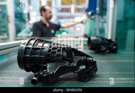 17 avril 2018, l'Allemagne, Ludwigsburg : un membre du personnel de l'équipementier automobile et spécialiste des filtres MANN +HUMMEL, prend le boîtier pour une huile d'un modul assmebly banc dans le hall d'assemblage de l'entreprise. Photo : Marijan Murat/dpa Banque D'Images