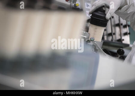 17 avril 2018, l'Allemagne, Ludwigsburg : un membre du personnel de l'équipementier automobile et spécialiste des filtres MANN +HUMMEL, les lieux d'un filtre à carburant dans un module de filtre à carburant dans la salle de l'assemblée. Photo : Marijan Murat/dpa Banque D'Images