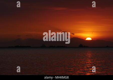 Manille, Philippines, Région de la capitale nationale. Apr 28, 2018. Les gens regardent le coucher du soleil comme il disparaît de la chaleur de la journée.Les couchers de soleil et disparaît au Mont Natib qui est à Bataan. Crédit : George Buid/ZUMA/Alamy Fil Live News Banque D'Images