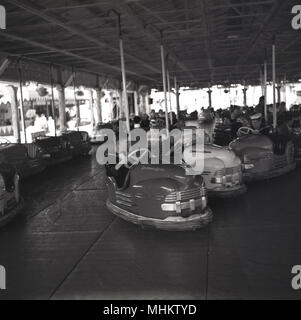 Années 1960, historiques, les jeunes hommes à Battersea fun fair appréciant les dodgems ou des autos-tamponneuses, Battersea Park, London, England, UK. La fête foraine a été construit dans le parc dans le cadre du Festival de Grande-Bretagne 1951 célébrations et a été une attraction importante pour les jeunes et les familles à cette époque. L'dodgem était détenu et exploité par le Botton Bros - leur nom est sur les voitures - Albert et Jim Botton qui a grandi dans une juste autour de Londres et le Sud de l'Angleterre. Banque D'Images