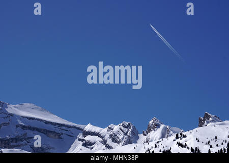 Avion à réaction pistes sentiers chemtrails dans le ciel bleu profond background Banque D'Images