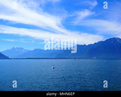 Vue sur le Lac Léman alpine landscapes vu de la promenade dans la ville de Montreux en Suisse européenne avec buoyes et Alpes suisses de montagne, ciel nuageux b Banque D'Images