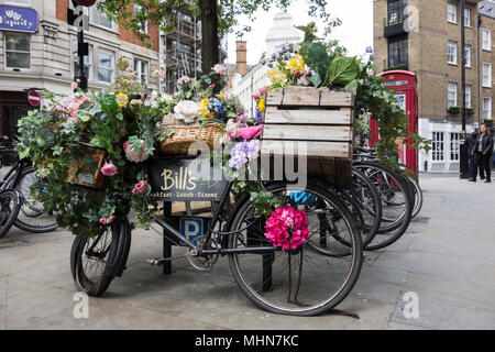 Un vélo stationné à l'extérieur floral Bill's restaurant à Covent Garden, Londres, UK Banque D'Images