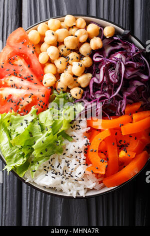 Bol Bouddha fraîchement préparé avec du chou rouge, les tomates, la laitue, le poivron, les pois chiches et le riz sur la table. vertical haut Vue de dessus Banque D'Images