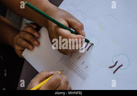 Les mains des enfants dessin sur un papier dans l'école Banque D'Images