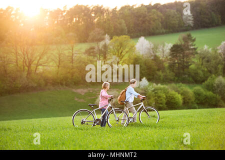 Beau couple avec des bicyclettes à l'extérieur au printemps la nature. Banque D'Images