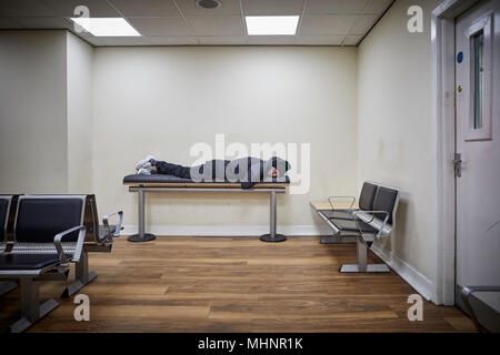 Glasgow en Ecosse, Glasgow Central homme dort sur banc de la salle d'attente Banque D'Images