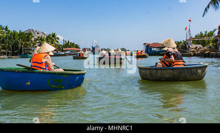 Les touristes circonscription panier de bambou bateaux vers la forêt de palmiers de noix de coco sur la rivière Banque D'Images