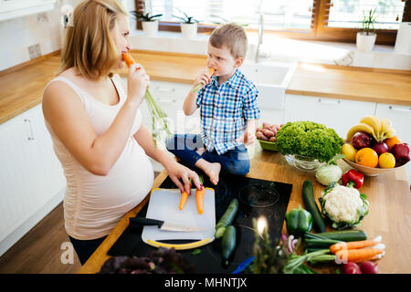 Maman enceinte et l'enfant la préparation de repas Banque D'Images