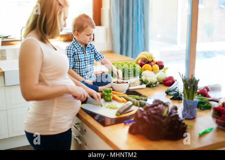 Mère enceinte et son fils preparing meal Banque D'Images