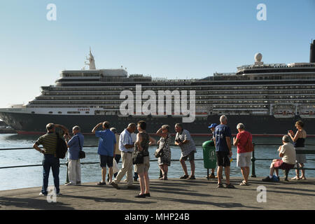 Un groupe de touristes du côté du port de Funchal, Madère. Le bateau de croisière Queen Elizabeth est amarré à l'arrière-plan Banque D'Images