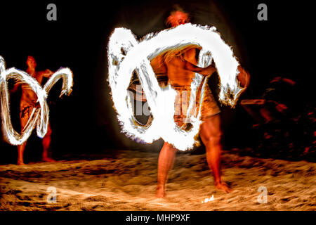 Danseuse polynésienne à l'aide de poteau de flamme sur fond noir Banque D'Images