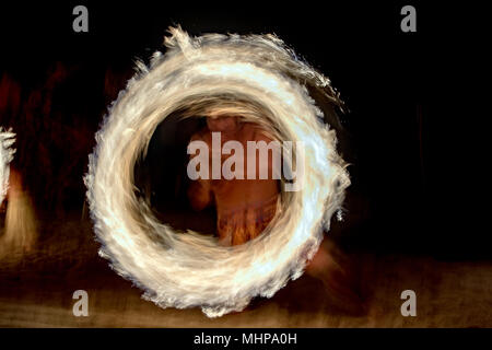 Danseuse polynésienne à l'aide de poteau de flamme sur fond noir Banque D'Images