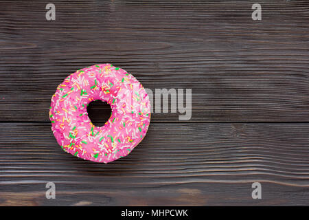 Un seul donut sur fond de bois brun Banque D'Images