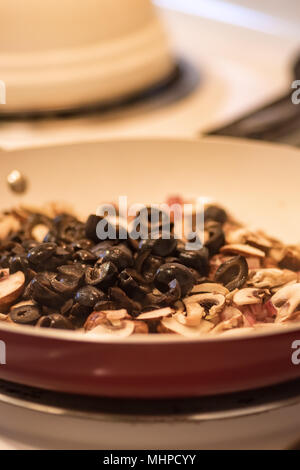 Olives noires, des champignons et d'oignon rouge haché en rouge et blanc poêle. Banque D'Images