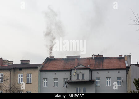 Oswiecim, Pologne - fumée noire sortant de la cheminée de l'immeuble, alors que le charbon-affectueux Pologne lutte avec killer le smog. La pollution de l'air. Banque D'Images