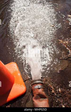 Les pousses de l'eau sur un feu ouvert et d'incendie sur la rue tandis que l'eau est nettoyée après le travail sur le système d'eau. Banque D'Images