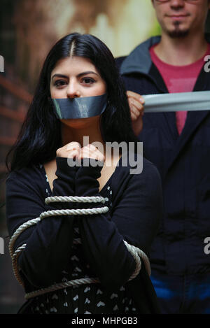 Close up of a mans couvrant une bouche de femme avec ruban, corde attaché avec ses mains. Concept de violence domestique ou d'enlèvement Banque D'Images