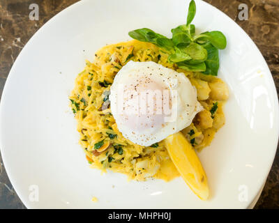 Petit-déjeuner un Kedgeree plat qui provient de l'Inde riz au curry oeuf raisins haddock fumé avec un oeuf poché sur le dessus Banque D'Images