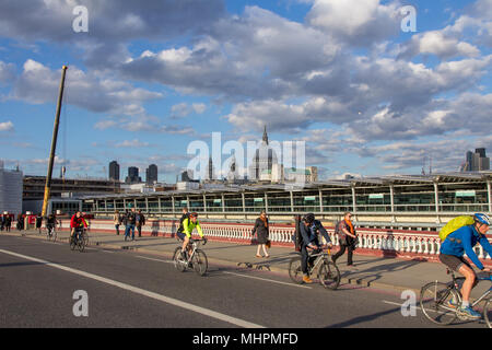 Piétons et cyclistes - la marche et le trajet à vélo au travail - à travers Blackfriars Bridge, London, UK avec la Cathédrale St Paul à l'arrière-plan. Banque D'Images