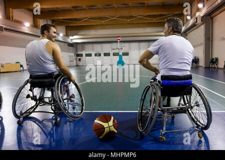 Mobilité sport hommes détente tout en jouant au basket-ball intérieur un terrain de basket-ball Banque D'Images