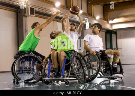 Mobilité sport hommes en action tout en jouant au basket-ball intérieur un terrain de basket-ball Banque D'Images