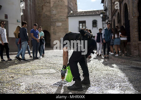 Granada, Espagne. 3 mai, 2018. Un policier se vide une bière dans un caniveau. De boire de l'alcool était interdit sur la Plaza Larga Square'El dÃ-a de la cruz'' ou 'DÃ-un de Las Cruces'' est l'une des plus belles fêtes de Grenade. Chaque 3e de mai de nombreuses rues, places et terrasses voir les autels de croix décorées avec des fleurs pour célébrer la Sainte Croix. Crédit : Carlos Gil/SOPA Images/ZUMA/Alamy Fil Live News Banque D'Images