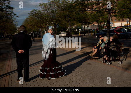 Une femme en robe flamenco typique vu marcher avec son mari. "El día de la Cruz" ou "Día de Las Cruces" est l'une des plus belles fêtes de Grenade. Chaque 3e de mai de nombreuses rues, places et terrasses voir les autels de croix décorées avec des fleurs pour célébrer la Sainte Croix. Banque D'Images