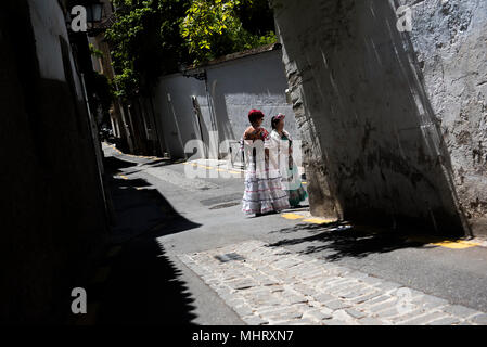 Deux femmes portant robe flamenco typique vu dans une rue de quartier El Realejo lors de la Dia de Las Cruces. "El día de la Cruz" ou "Día de Las Cruces" est l'une des plus belles fêtes de Grenade. Chaque 3e de mai de nombreuses rues, places et terrasses voir les autels de croix décorées avec des fleurs pour célébrer la Sainte Croix. Banque D'Images