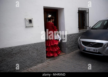 Une femme avec son fils un portant robe Flamenco typique vu dans une rue de quartier Albaicin au cours de la Dia de Las Cruces à Grenade."el día de la Cruz" ou "Día de Las Cruces" est l'une des plus belles fêtes de Grenade. Chaque 3e de mai de nombreuses rues, places et terrasses voir les autels de croix décorées avec des fleurs pour célébrer la Sainte Croix. Banque D'Images