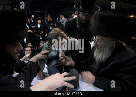 À l'âge de trois ans garçon juif prend part à la traditionnelle cérémonie Halake, une première coupe de cheveux du rabbin de la dynastie hassidique dans Pinsk-Karlin Geula quartier religieux lors de la fête de Lag BaOmer qui marque la célébration, interprétée par certains comme l'anniversaire de la mort de Rabbi Shimon Bar Yochai, un des grands sages du judaïsme, il y a quelque 1800 ans et le jour où il a révélé les secrets de la kabbale un texte historique de la mystique juive Banque D'Images