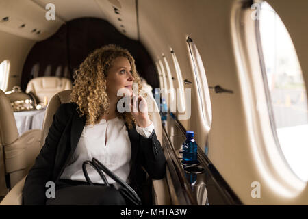 Businesswoman voyager en jet privé Banque D'Images