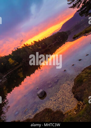 Un moment spectaculaire lever du soleil dans les highlands écossais au bord d'une magnifique loch Banque D'Images